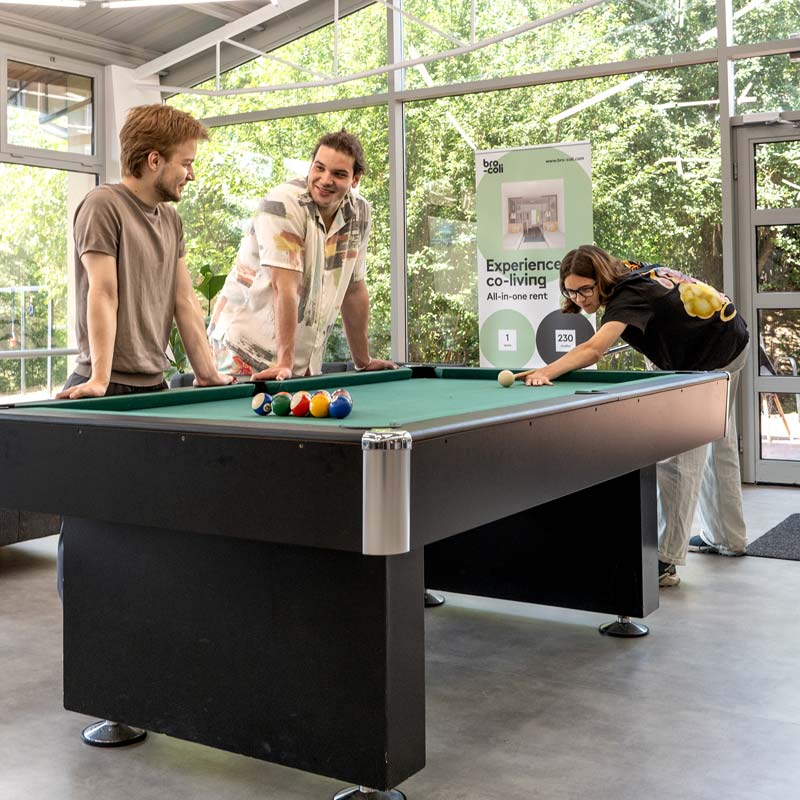Group of friends playing pool in bro-coli