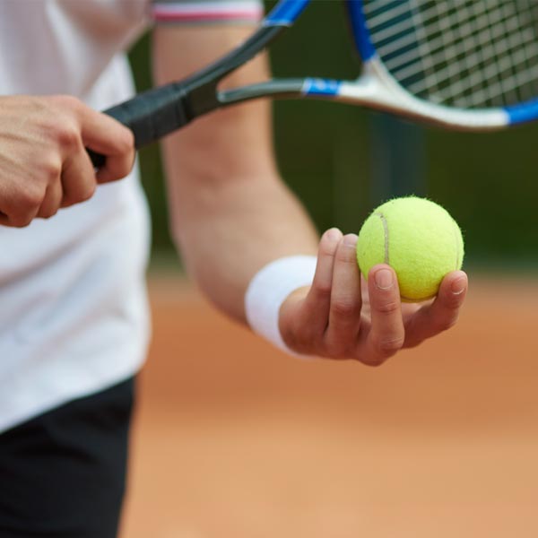 Man holding a tennis ball and tennis rocket